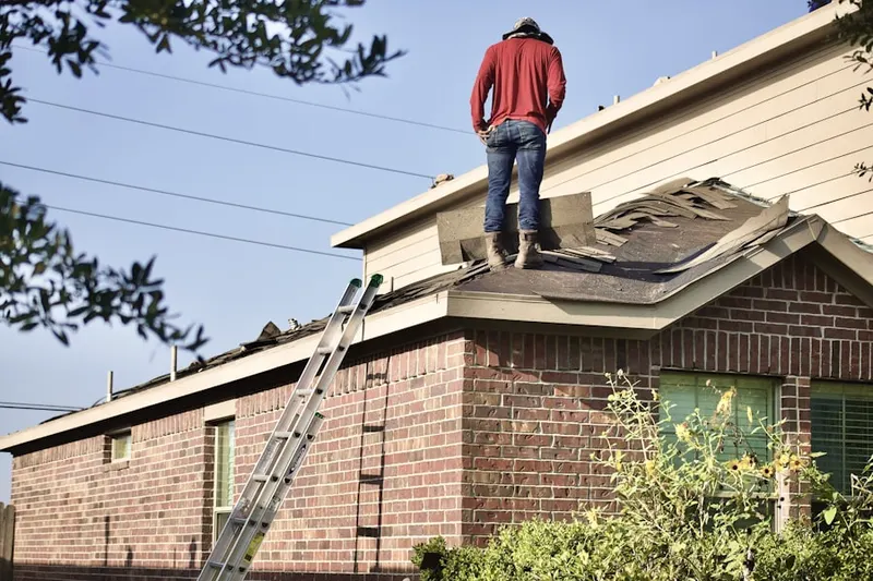 Professional roofer working on a residential roof in Gebhart
